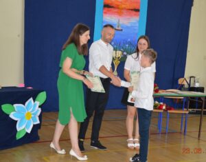 Kacper odbiera dyplom od Pani Kingi Soliwody i pana Marcina Banaszkiewicza